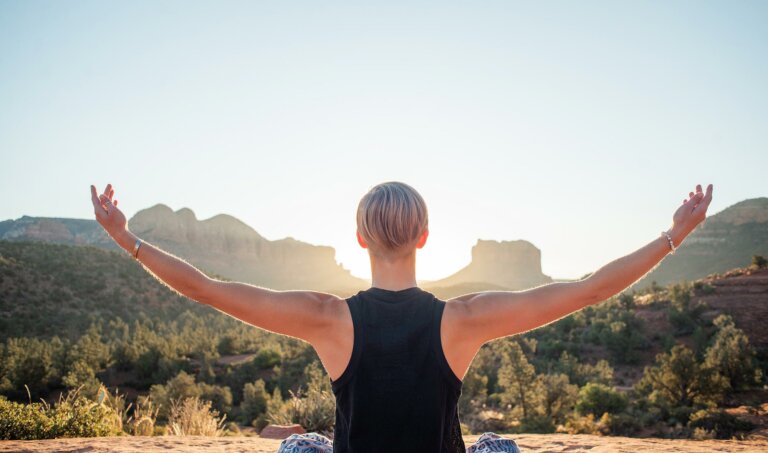 Woman in desert with arms outstretched